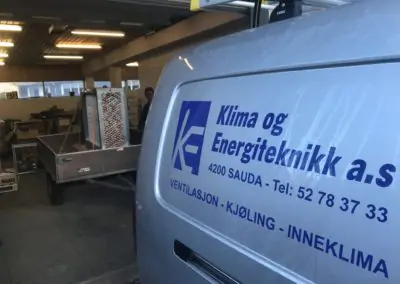 Bil som det står Klima og Energiteknitt på med en tilhenger og last